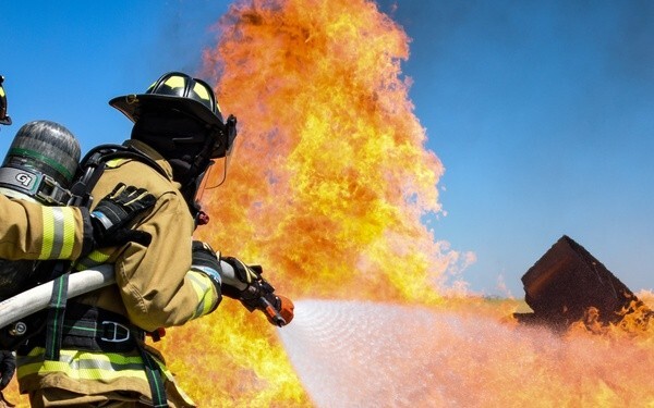 firefighter extinguishing fire with water hose