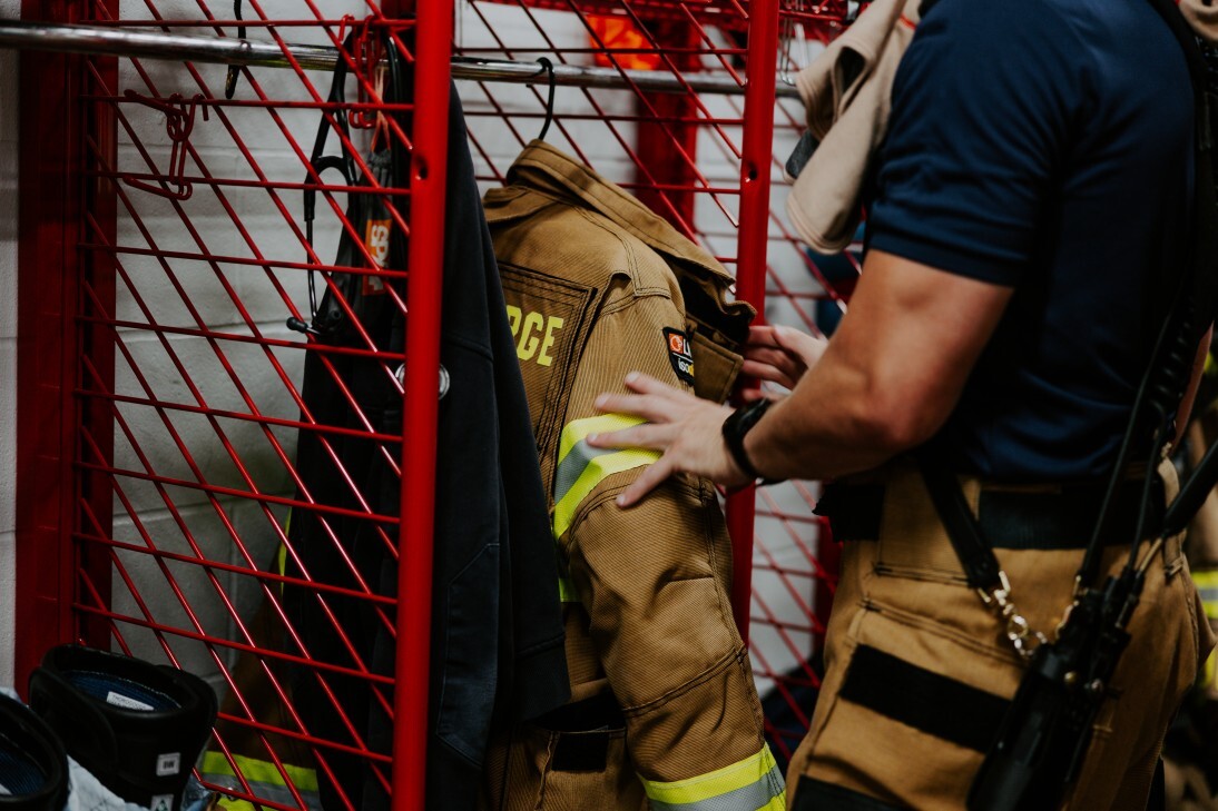 firefighter putting gear in locker