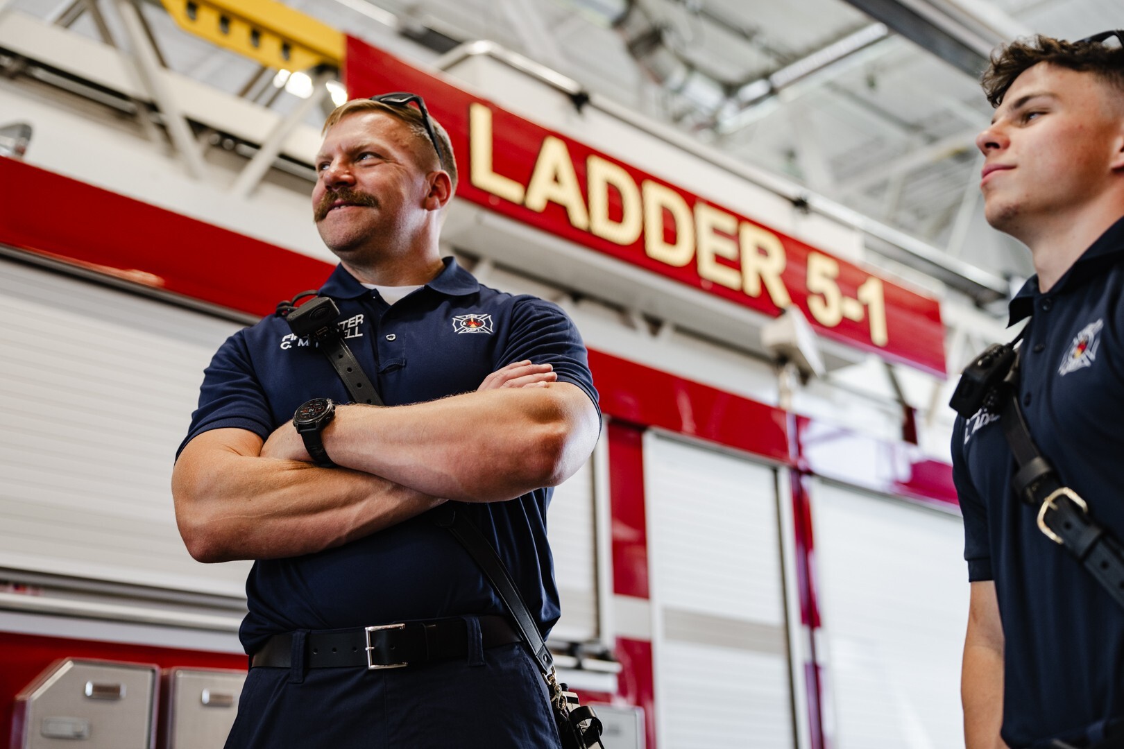 Firefighter with handlebar mustache in front of fire truck