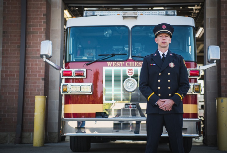 Firefighter officer standing in front of fire engine