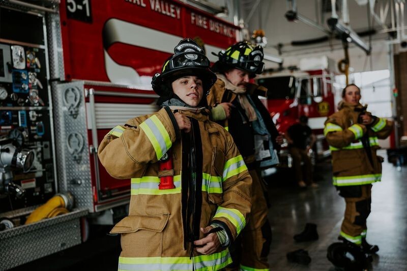 Firefighters gearing up next to fire truck