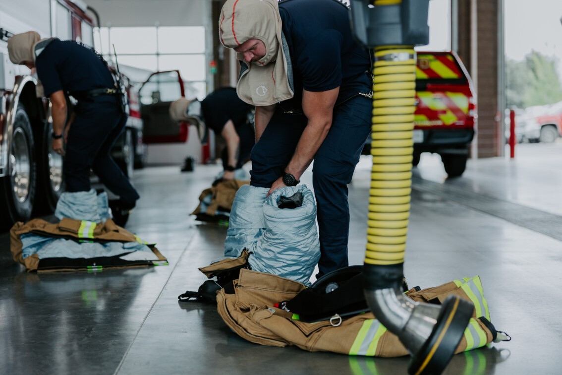 firefighters gearing up into uniforms wearing base layers